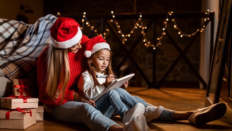 девочка с мамой пишет письмо Санта Клаусу
